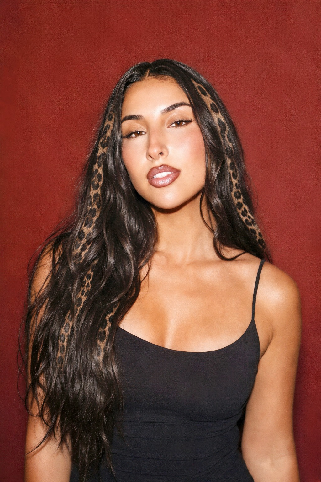 Zeina with leopard-print highlights against a red backdrop